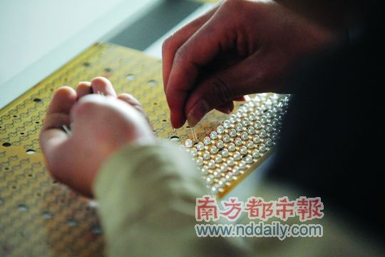 工人忙著安裝用于燈具發(fā)光的LED燈珠，這類工作處于LED燈具生產(chǎn)的最下游。資料圖